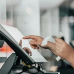 a person is using a pos machine in a store