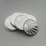 a set of four silver coins sitting on top of a table