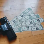 a pile of money sitting on top of a wooden floor